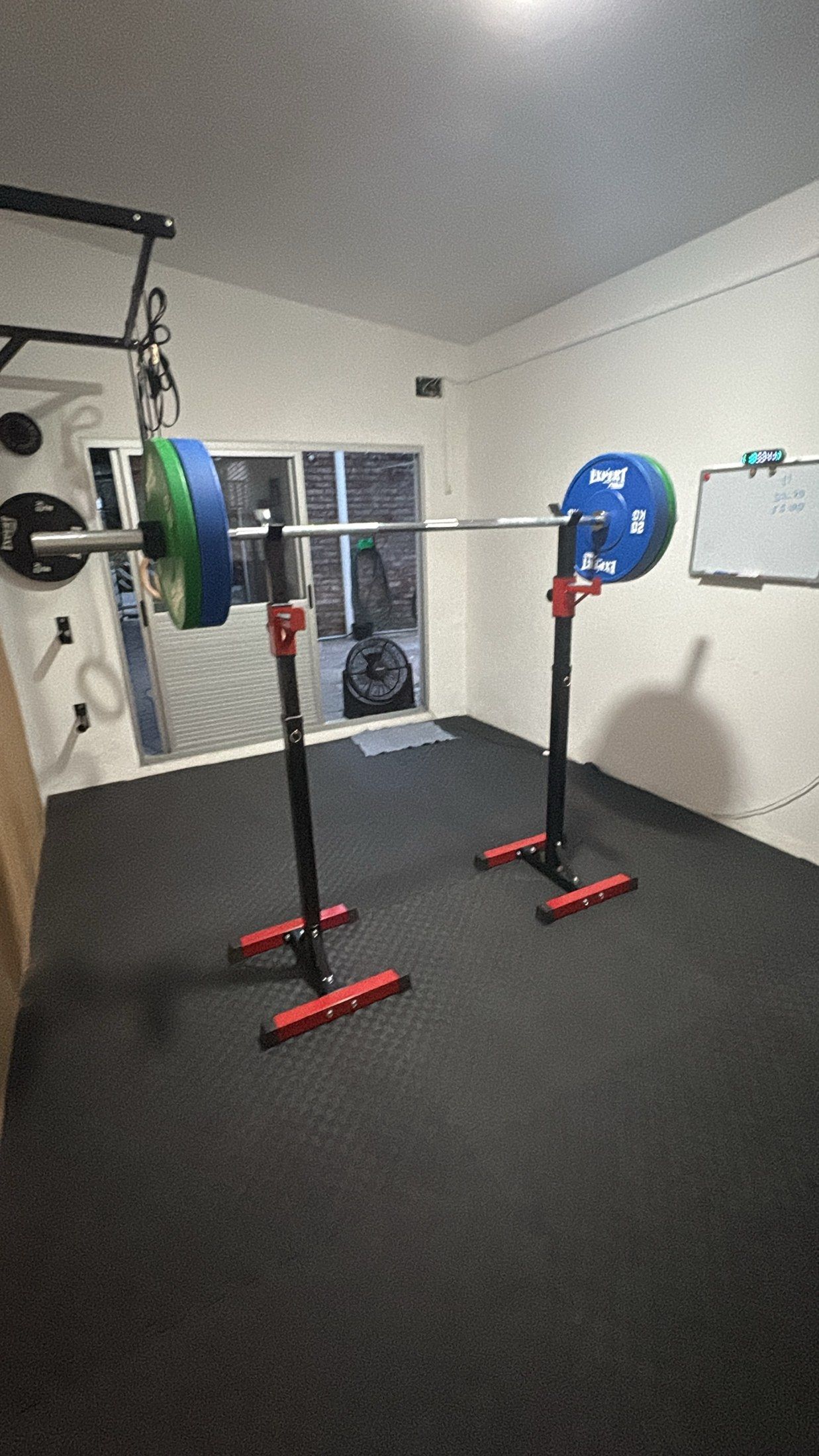Barra olímpica cargada con discos sobre soportes de sentadilla.